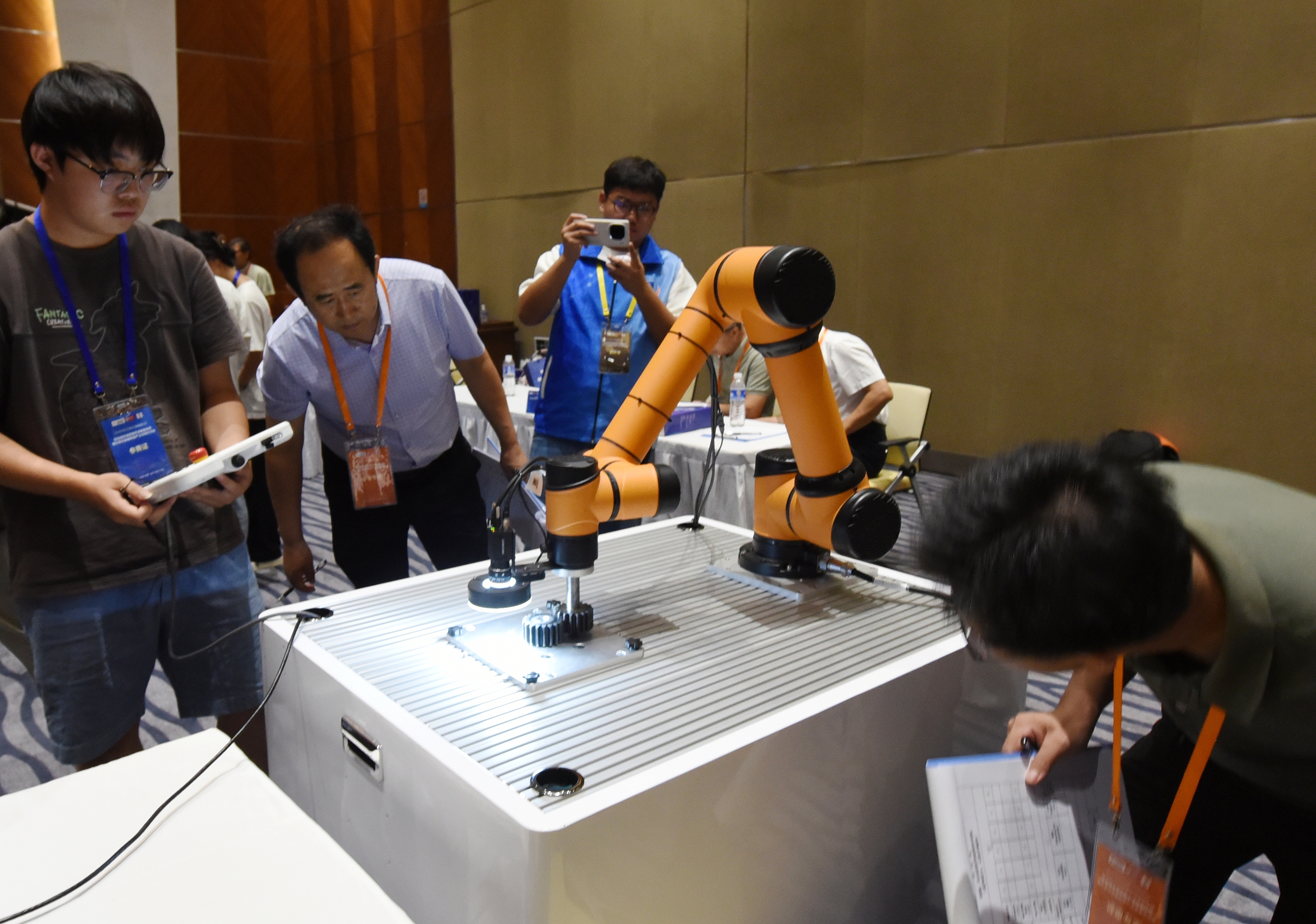 2025年中國大學(xué)生機(jī)械工程創(chuàng)新創(chuàng)意大賽智能精密裝配賽京津冀魯聯(lián)賽現(xiàn)場(chǎng)，評(píng)委對(duì)參賽選手進(jìn)行實(shí)操調(diào)試評(píng)比。